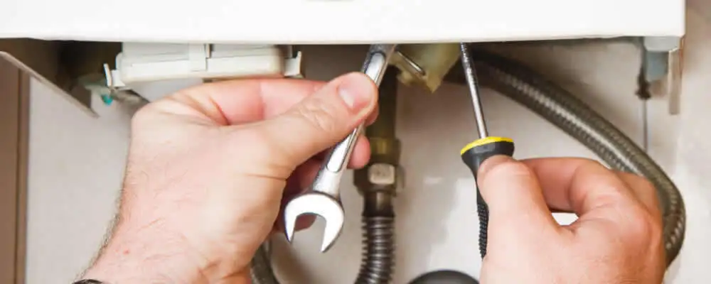 Boiler repair technician tightening pipe fittings and connections in Duluth, MN