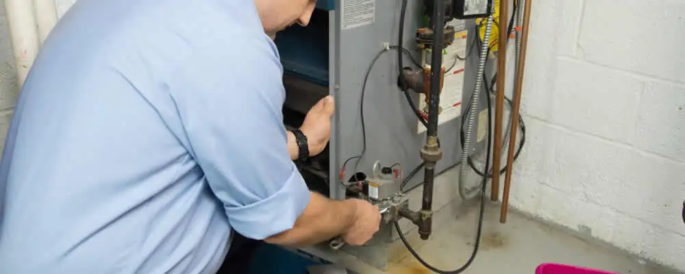 Furnace repair technician inspecting and servicing a home heating system in Duluth, MN
