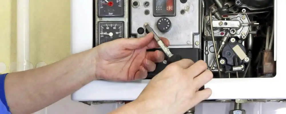 Heating repair technician adjusting boiler controls and components in Duluth, MN
