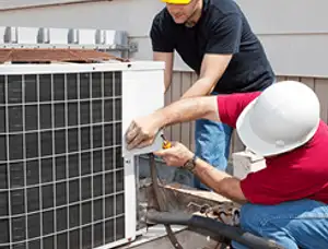 HVAC technicians repairing an outdoor AC unit on a rooftop in Duluth, MN