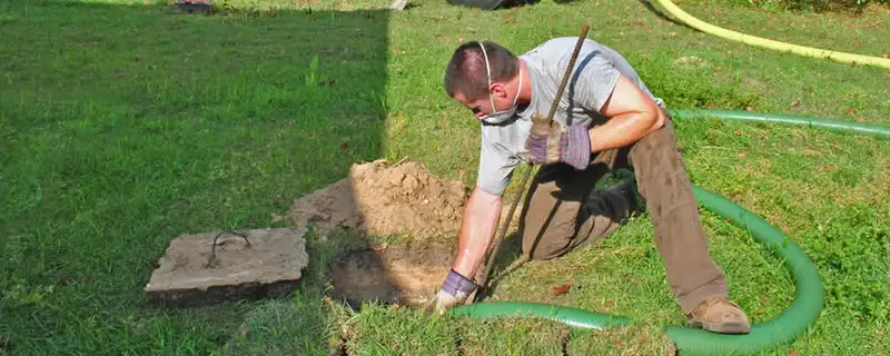 Septic pumping technician servicing a residential septic tank in Duluth, MN