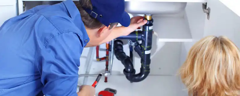 Plumber repairing under-sink drain pipes and fittings in Duluth, MN
